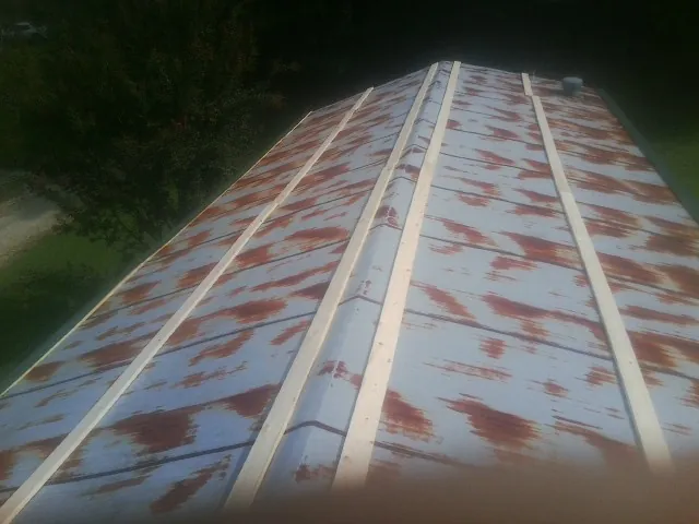 Rusted metal roof panels with new wood purlins before replacement — Storm Damage Roof Repair in Cedar Glen by Roofing Brothers