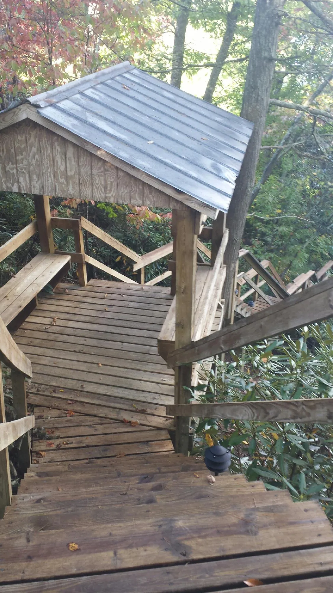 Metal roofed shelter over wooden steps on a wooded walkway — Skylight Repair & Installation work by our crew in Cedar Glen